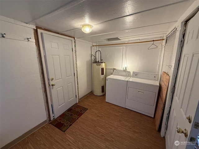 laundry area featuring hardwood / wood-style flooring, independent washer and dryer, and electric water heater