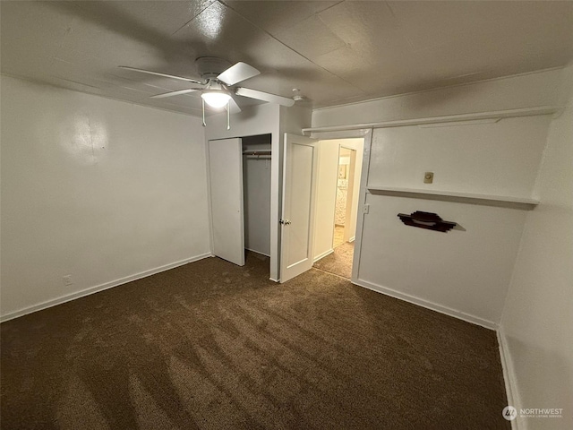 unfurnished bedroom with ceiling fan, a closet, and dark colored carpet