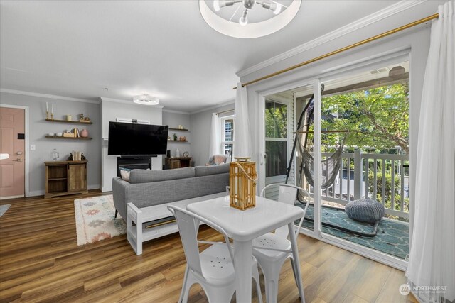 dining space with hardwood / wood-style flooring, ornamental molding, and plenty of natural light