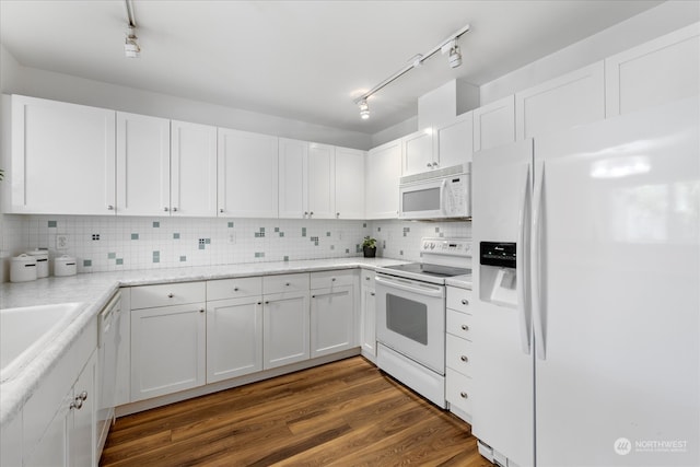 kitchen with white cabinets, dark hardwood / wood-style flooring, white appliances, and rail lighting