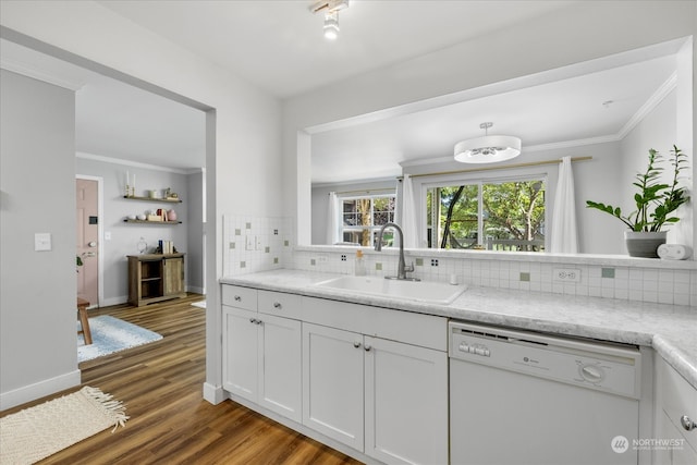 kitchen with white cabinets, hardwood / wood-style floors, white dishwasher, sink, and backsplash