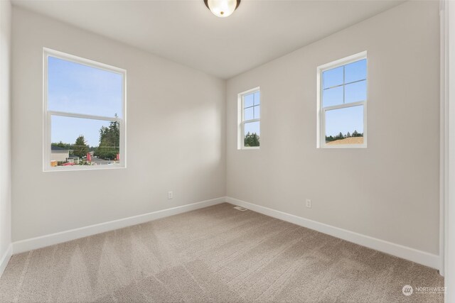 carpeted spare room featuring baseboards