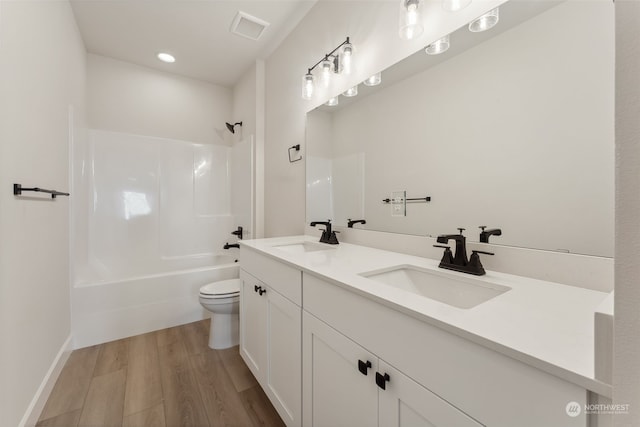 full bathroom featuring vanity, shower / washtub combination, hardwood / wood-style floors, and toilet