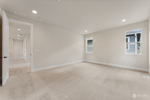 spare room with recessed lighting, visible vents, and light colored carpet