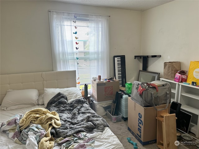 bedroom featuring multiple windows, carpet, and a textured ceiling