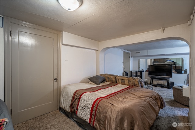 bedroom featuring a textured ceiling and carpet flooring