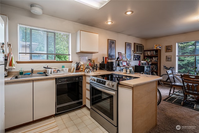 kitchen with black dishwasher, white cabinets, sink, kitchen peninsula, and stainless steel range with electric cooktop