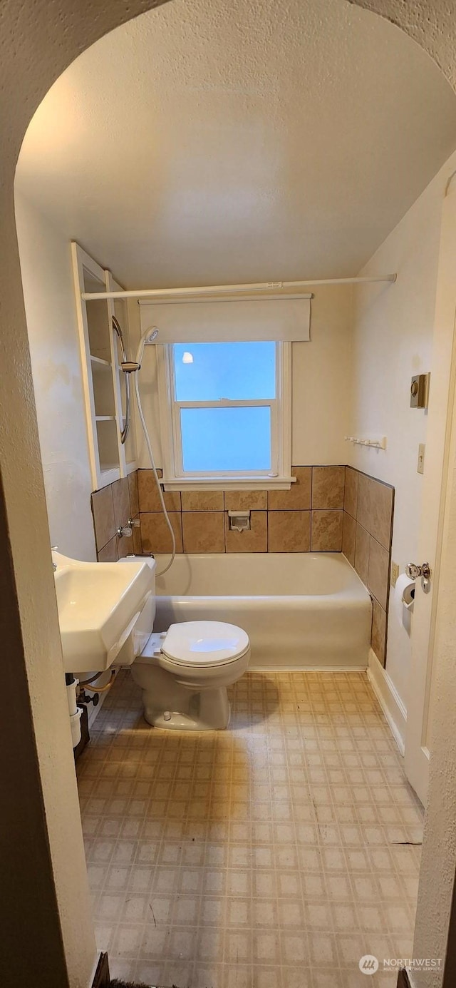 full bathroom featuring sink, toilet, bathtub / shower combination, and a textured ceiling