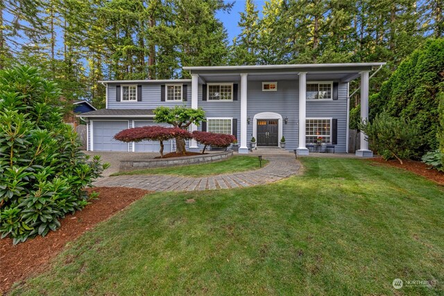 view of front of house featuring a garage and a front lawn