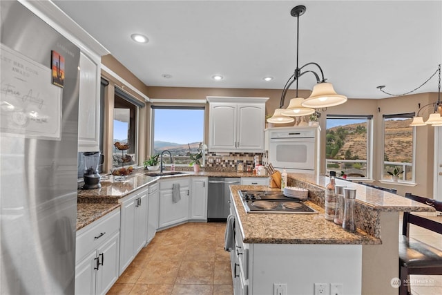 kitchen with a kitchen island, pendant lighting, sink, white cabinets, and stainless steel appliances