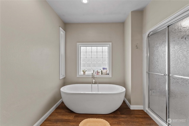 bathroom with plus walk in shower and hardwood / wood-style floors