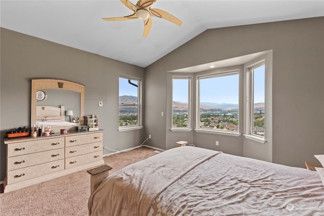 carpeted bedroom with a mountain view, vaulted ceiling, and ceiling fan