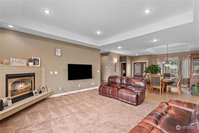 carpeted living room featuring a fireplace and a tray ceiling