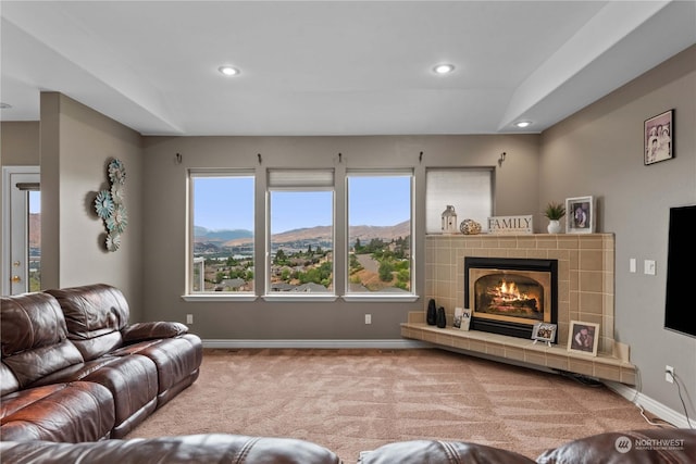 carpeted living room featuring a tiled fireplace