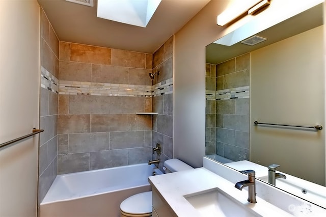 full bathroom with vanity, tiled shower / bath combo, and toilet