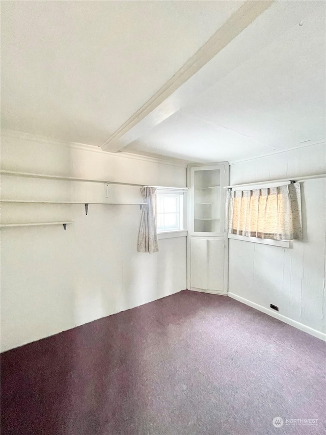 bonus room featuring beamed ceiling and carpet