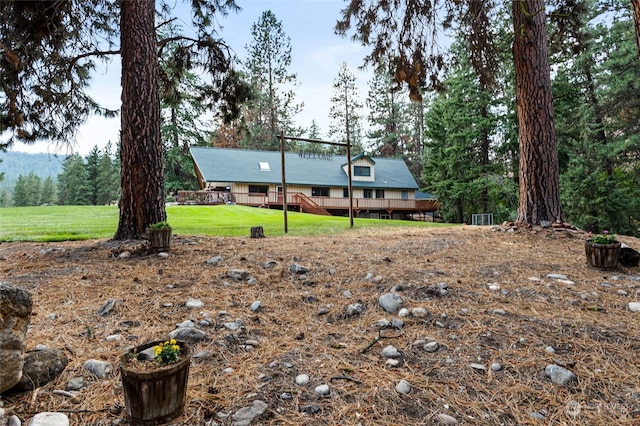 view of front of house with a front yard and a wooden deck