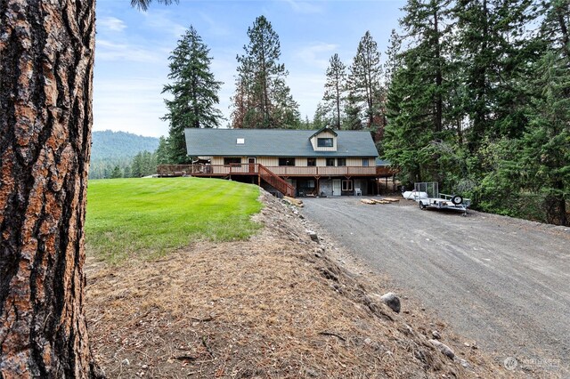 view of front of property featuring a front yard and a wooden deck