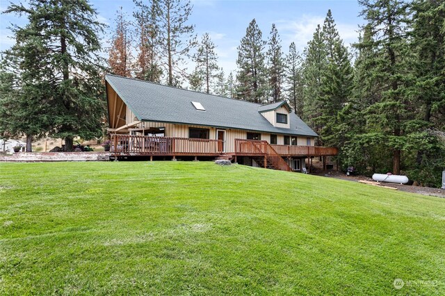 back of house featuring a lawn and a deck