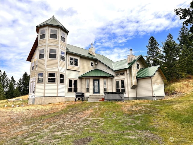 back of property featuring a hot tub