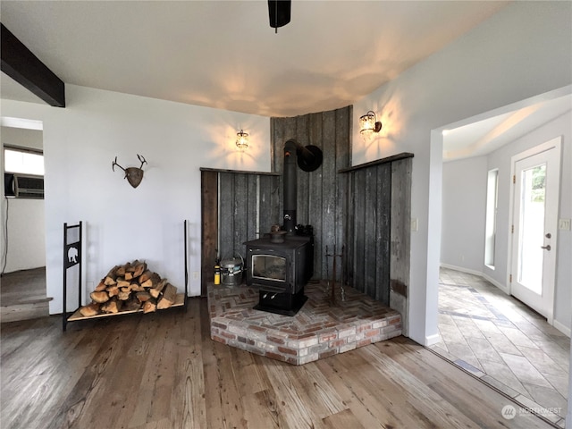 living room with hardwood / wood-style floors, a wood stove, and cooling unit