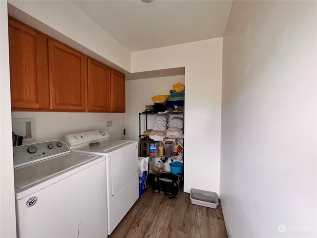 laundry area with cabinets, washer and clothes dryer, and light hardwood / wood-style floors