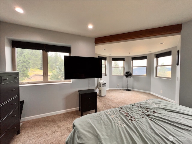 bedroom with beam ceiling and light carpet