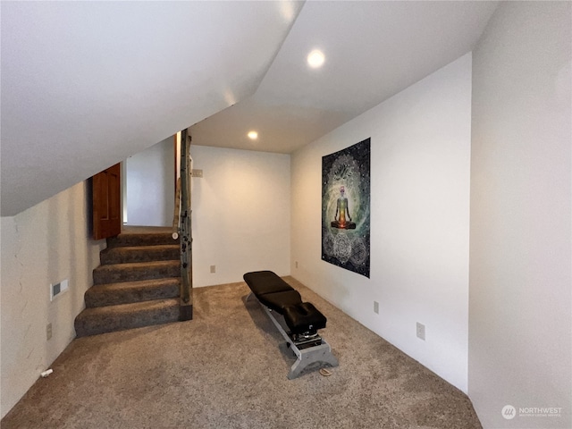 exercise room featuring carpet floors and vaulted ceiling