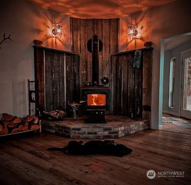 interior details featuring a wood stove and wood-type flooring