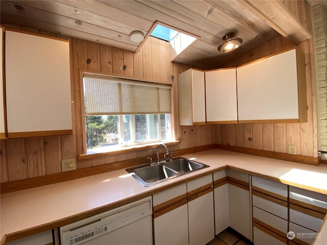 kitchen featuring sink, a skylight, white cabinetry, and dishwasher