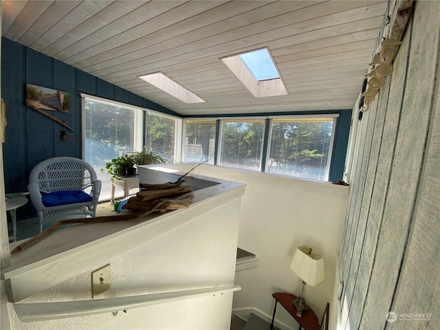 sunroom / solarium with wood ceiling and lofted ceiling with skylight