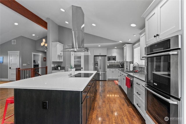 kitchen featuring vaulted ceiling with beams, stainless steel appliances, dark wood-type flooring, a sink, and island exhaust hood