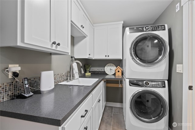 clothes washing area with stacked washer and dryer, cabinet space, and a sink