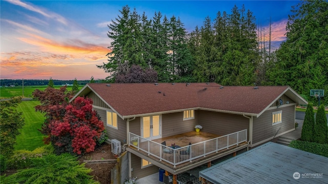 view of front facade featuring a shingled roof, ac unit, and a wooden deck