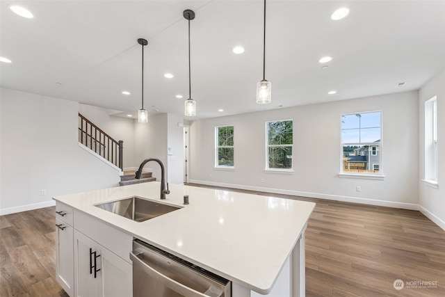 kitchen with white cabinetry, dishwasher, sink, an island with sink, and hanging light fixtures