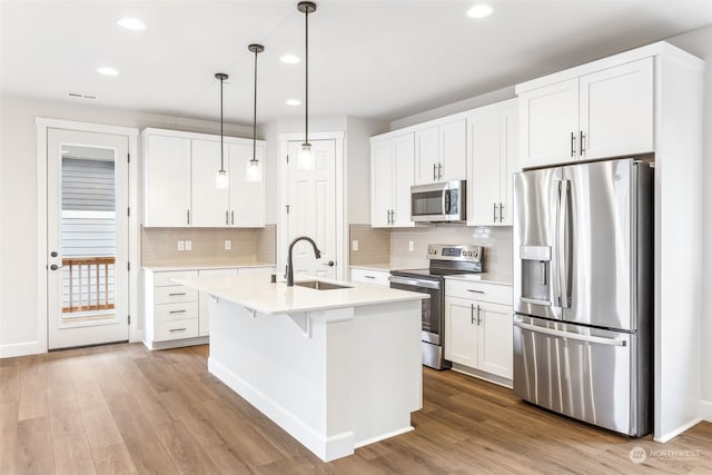 kitchen featuring pendant lighting, white cabinetry, stainless steel appliances, and sink