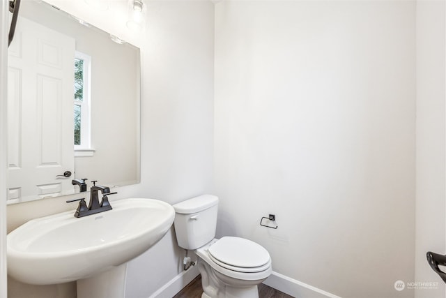 bathroom with hardwood / wood-style flooring, sink, and toilet