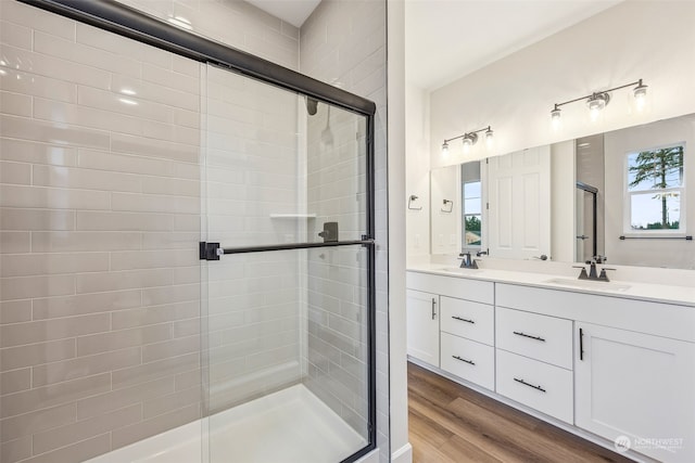 bathroom featuring hardwood / wood-style flooring, vanity, and a shower with door