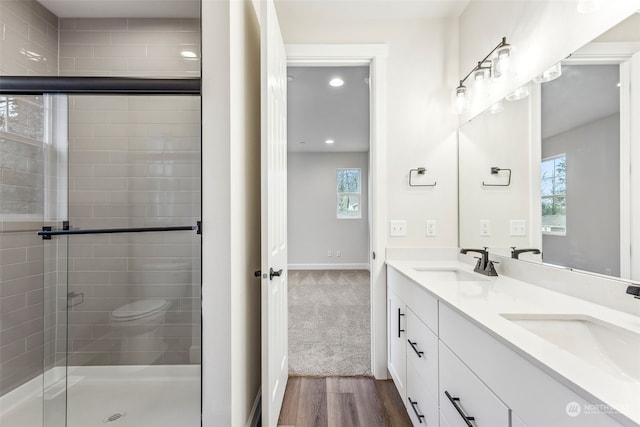 bathroom featuring vanity, an enclosed shower, hardwood / wood-style floors, and a wealth of natural light