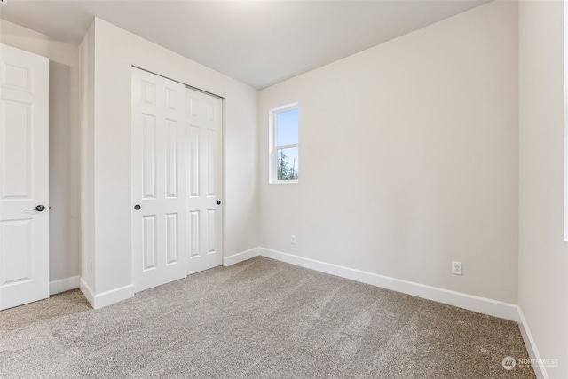 unfurnished bedroom featuring light carpet and a closet