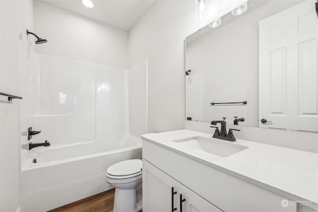 full bathroom with vanity, toilet, hardwood / wood-style floors, and shower / bathing tub combination