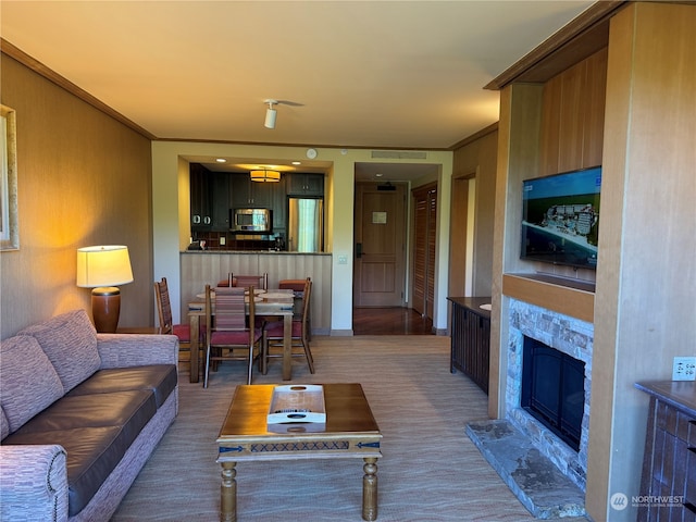 living room with carpet floors, a premium fireplace, and crown molding