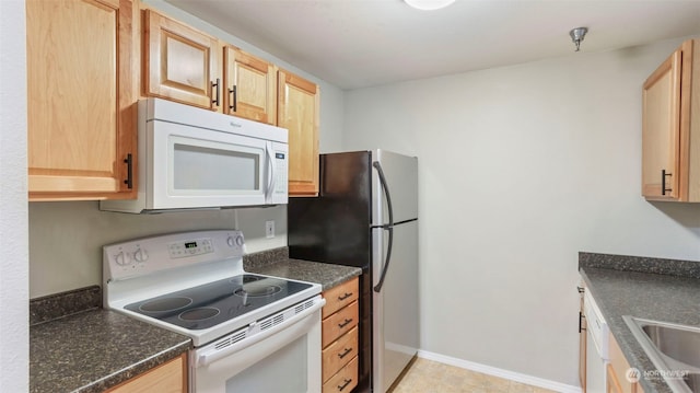 kitchen featuring light tile patterned flooring, light brown cabinets, and white appliances