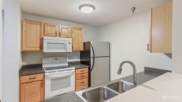 kitchen with light brown cabinetry, sink, and white appliances