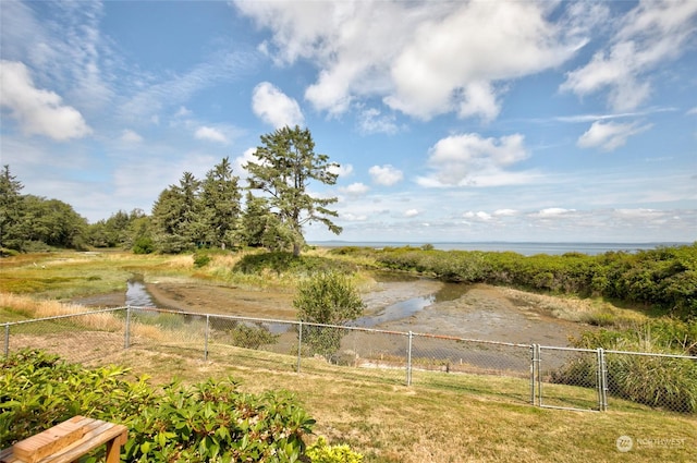 view of yard with a gate, a water view, and fence