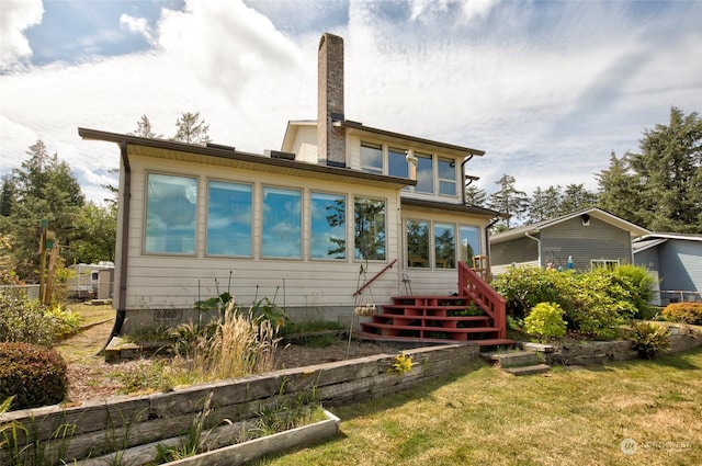 rear view of property with a yard and a chimney