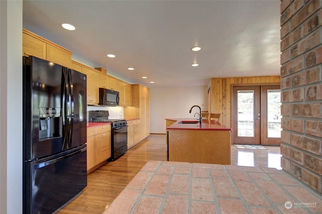 kitchen featuring tile counters, a sink, black appliances, french doors, and recessed lighting