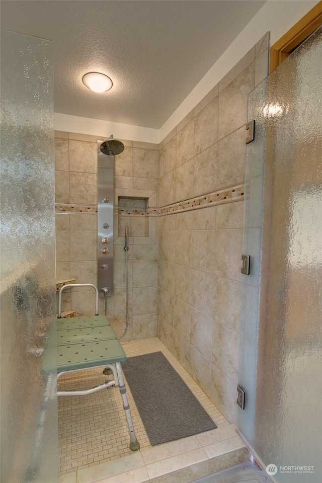 bathroom with a shower stall and a textured ceiling