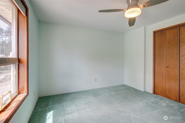 unfurnished bedroom featuring a closet, a ceiling fan, and carpet