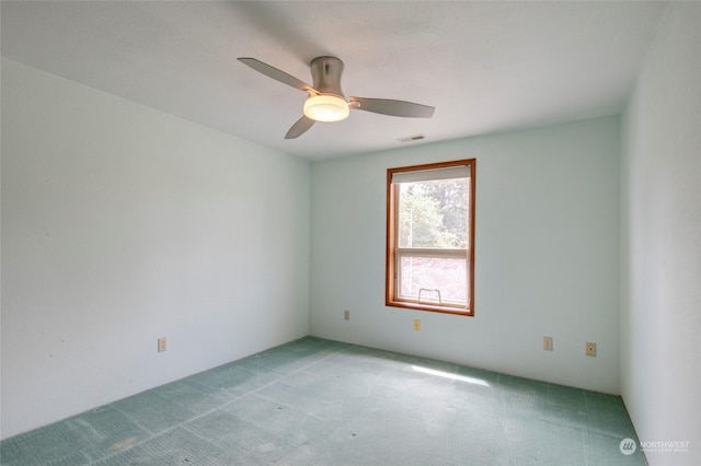 spare room with light carpet, a ceiling fan, and visible vents